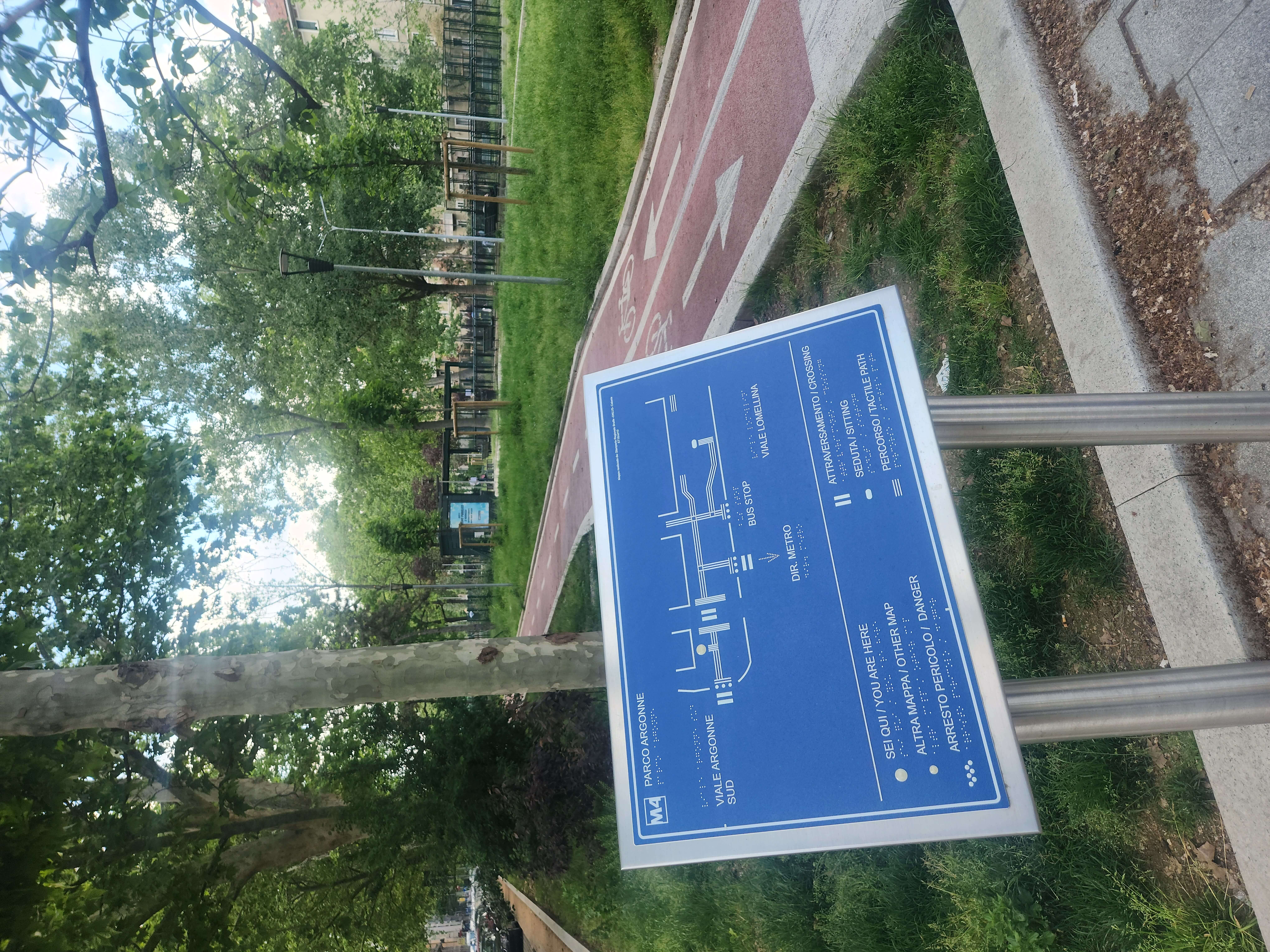 Mappa tattile blu situata nel Parco Argonne di Milano, indicante direzioni, fermate bus e percorsi ciclabili accessibili.