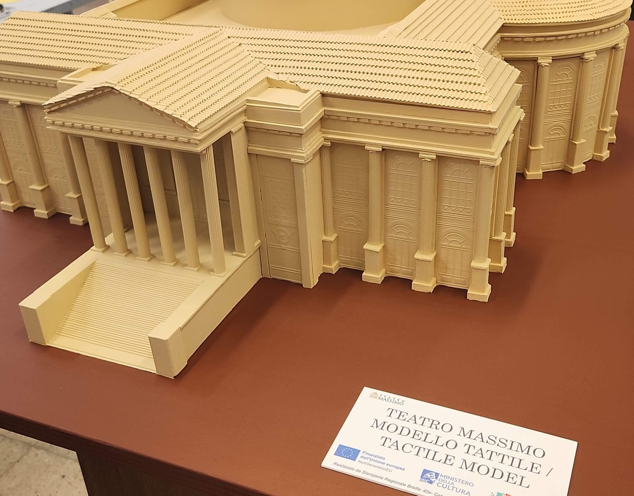 Dettaglio ravvicinato del pronao con colonne del modellino tattile del Teatro Massimo, completo di etichetta informativa."