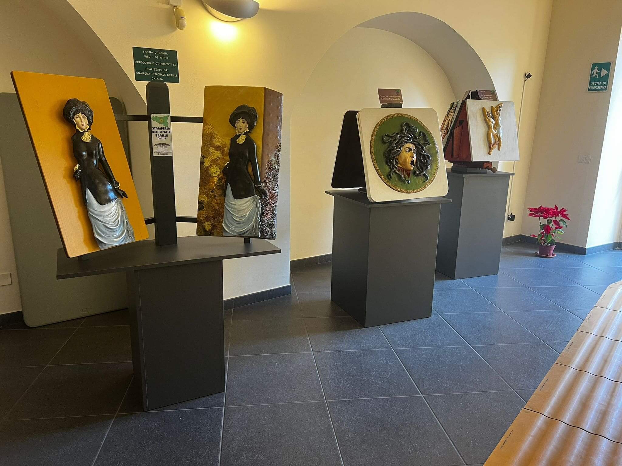Esposizione museale di opere d'arte tattili, incluse riproduzioni della Medusa di Caravaggio e dipinti di De Nittis.