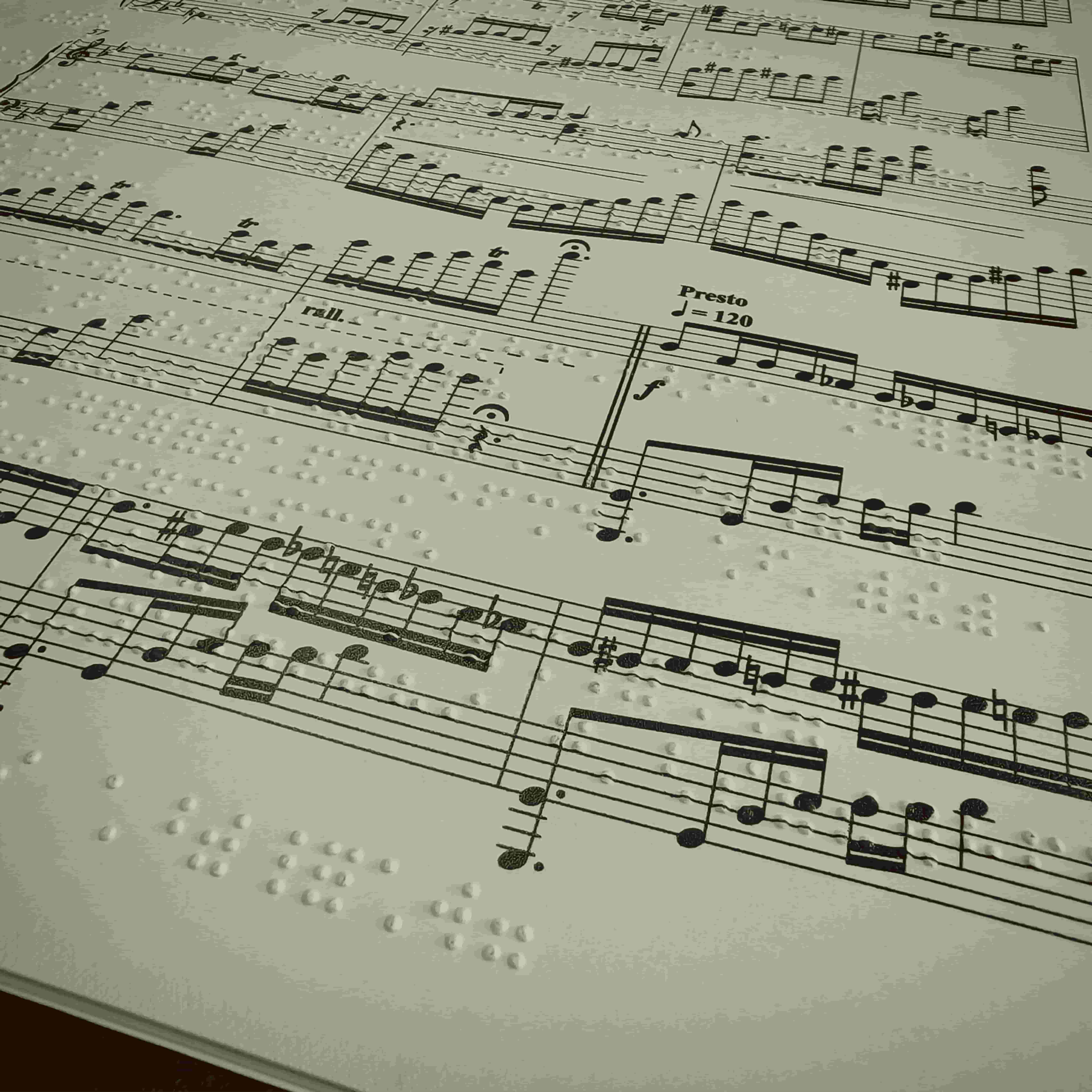 Spartito musicale inclusivo che combina la notazione tradizionale a stampa con il sistema a rilievo Braille.