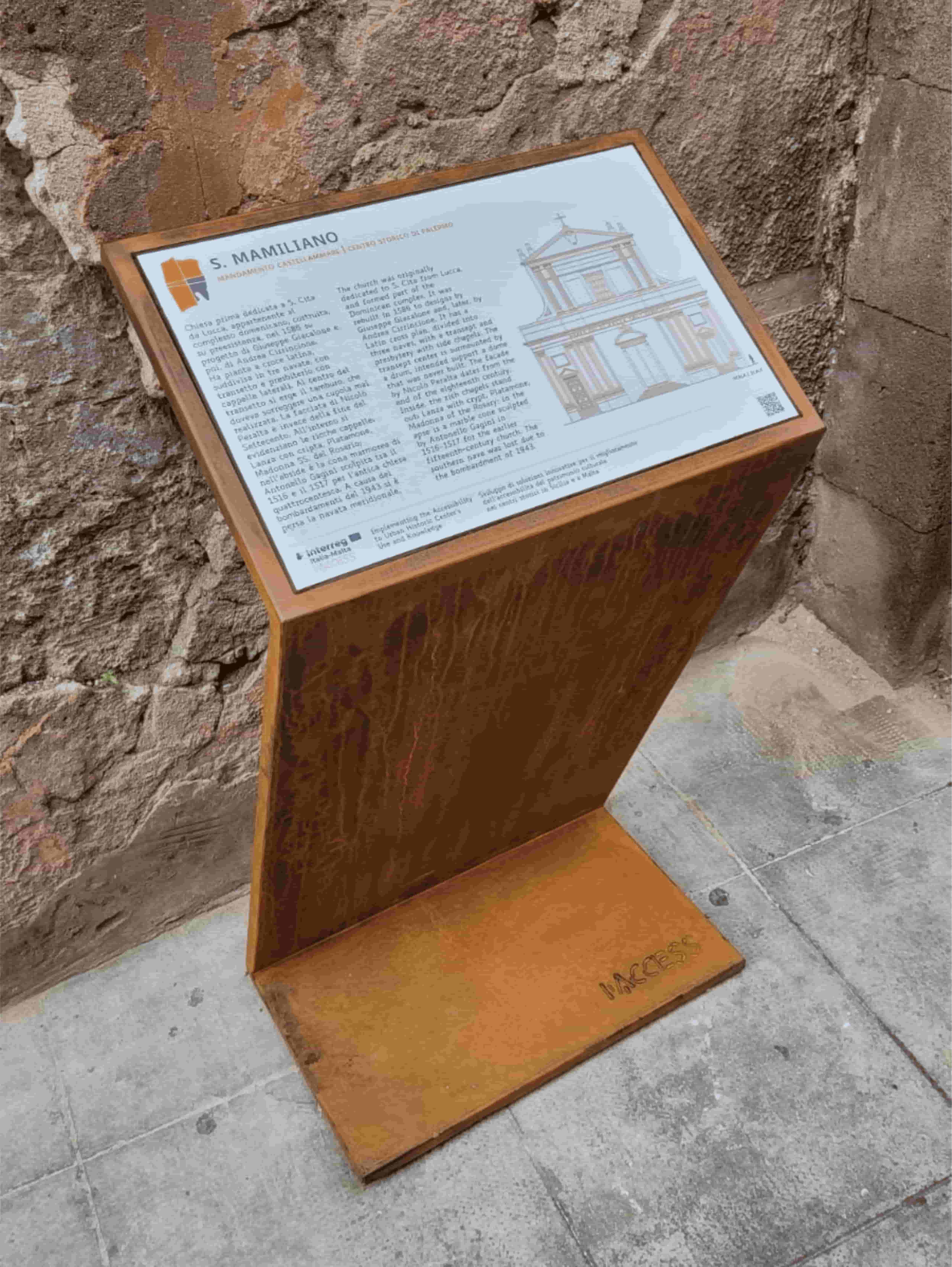 Pannello informativo esterno in metallo sulla Chiesa di S. Mamiliano, con testo bilingue e disegni architettonici.